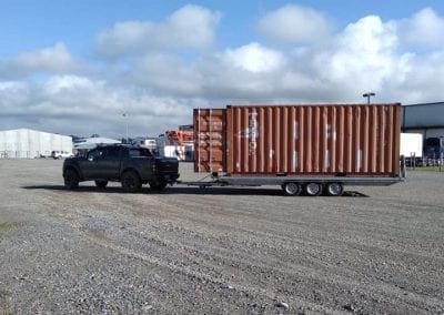 Shipping container on triple axle trailer